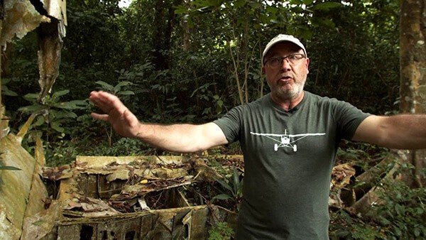 Man in jungle near plane wreckage