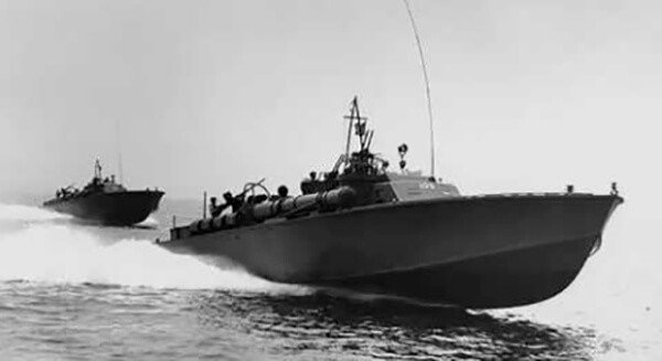 Two PT boats from World War II navigate the water, showcasing vintage naval vessels.