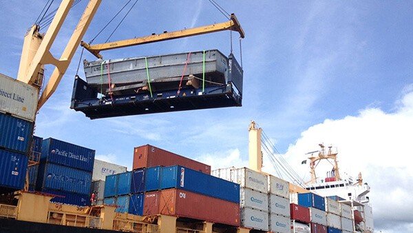 Crane lifting cargo container onto a ship, part of a shipping video