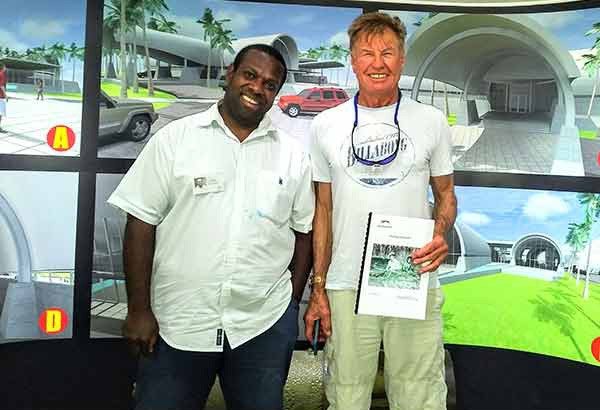Two men smiling in front of a mural depicting futuristic buildings and palm trees.