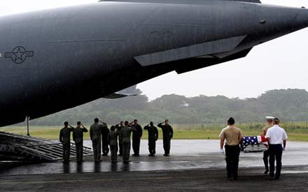 Elwood J Euart: Honor guard carries casket from military aircraft.