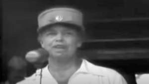 Woman in a hat speaking, potentially from a historical video