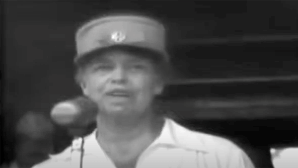 Woman in a hat speaking, potentially from a historical video