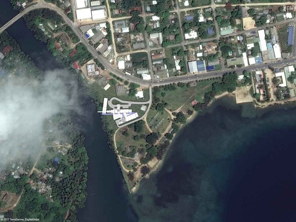 Aerial view of a coastal town with a modern building complex near the water.