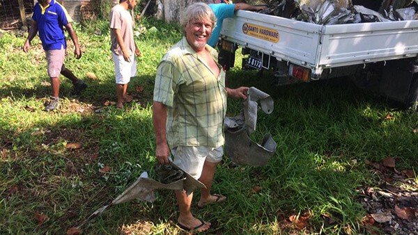 Man with airplane debris and Santo Hardware truck