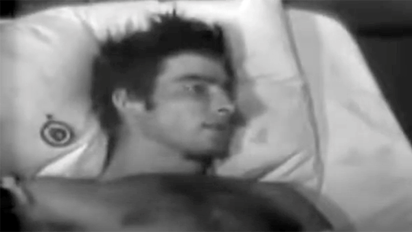 Young man lying in bed, looking to the side