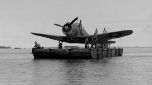 WWII US Navy floatplane on a barge, men aboard
