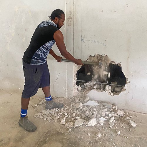 Worker demolishing wall during museum renovations