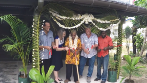 Group at ribbon cutting ceremony for new building, elder in center