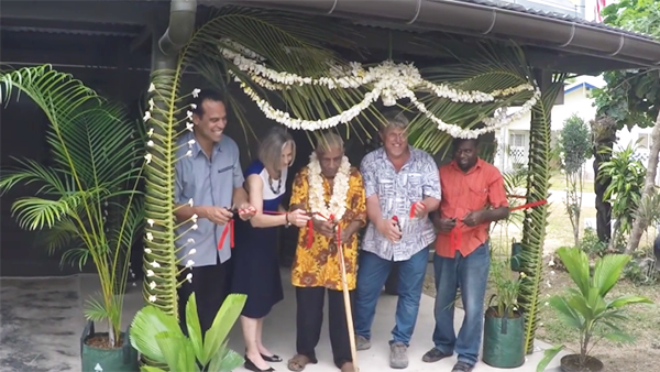 Group at ribbon cutting ceremony for new building, elder in center