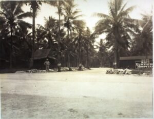 25th Evacuation Hospital entrance with palm trees and military personnel