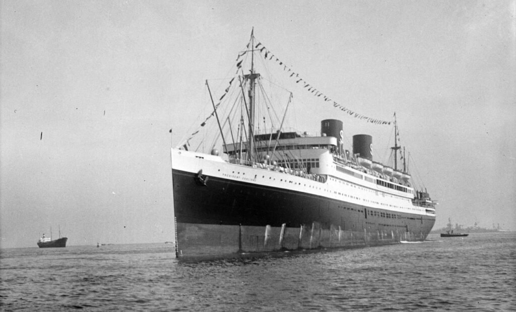 President Coolidge ocean liner sailing in ocean with flags and people on deck